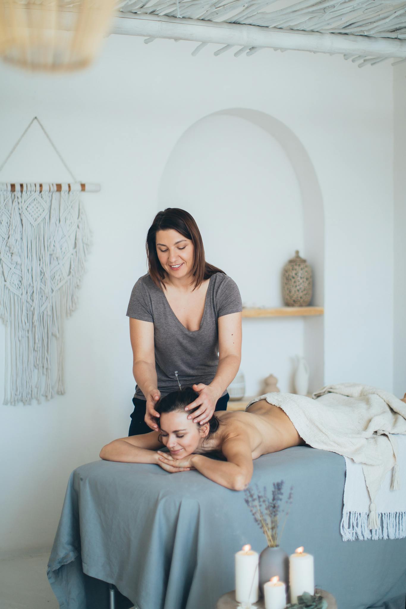 Woman receiving a relaxing head massage in a serene spa setting, promoting wellness and relaxation.
